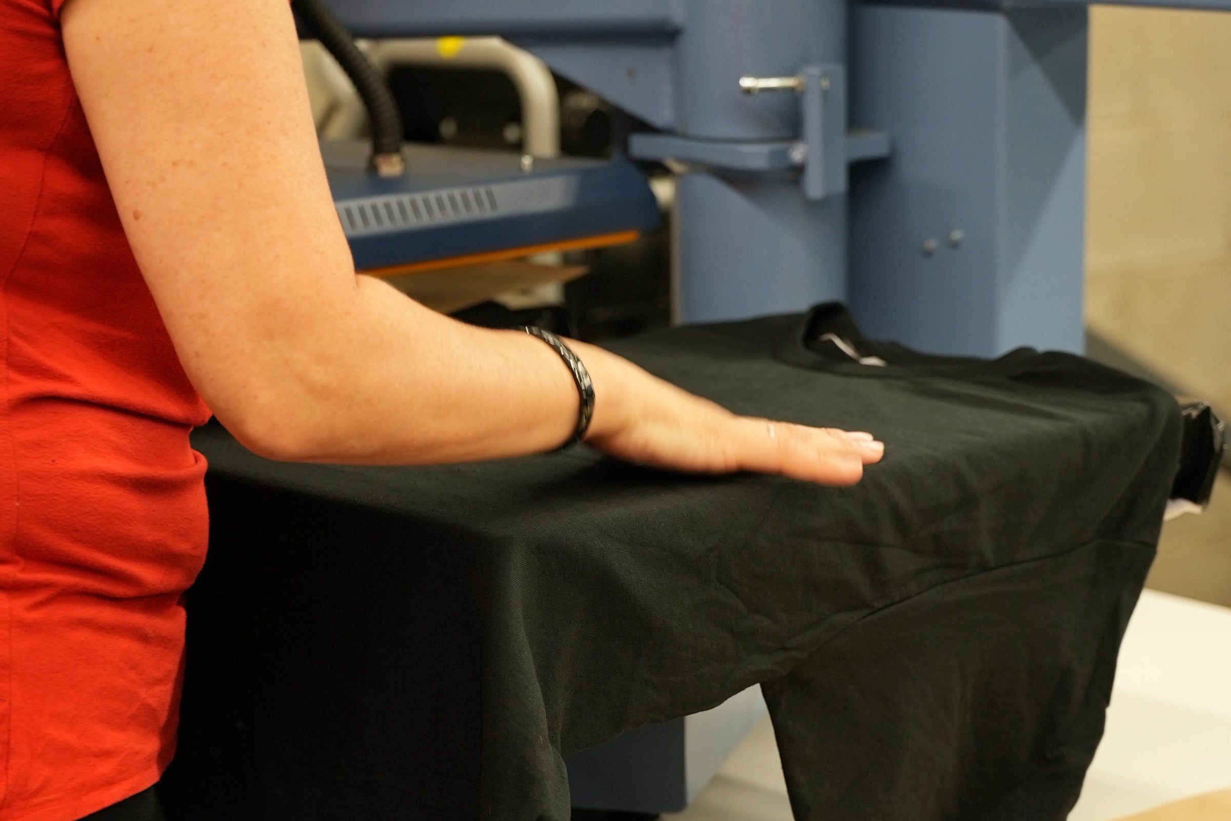 Employée d’Uniformes Town & Country en train de personnaliser un chandail pour une entreprise.