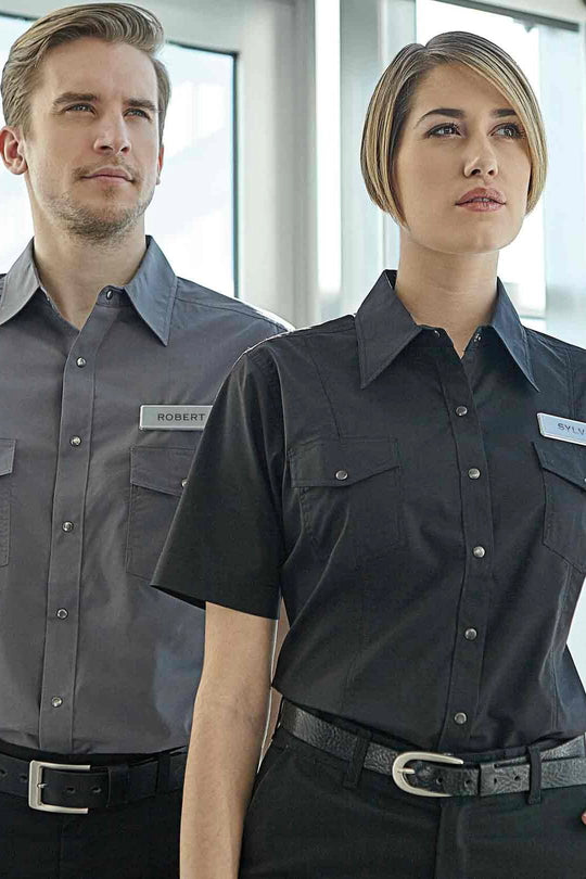 Une femme et un homme oeuvrant en entretien et portant des uniformes de travail du magasin Uniformes Town & Country, à Laval